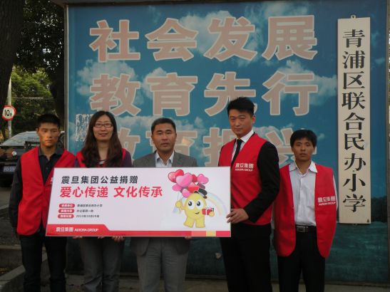 家具上海事业部闵青责任中心李木子经理(右二)、行销组刘彤经理(左二)代表震旦集团现场捐赠，青浦区联合民办小学校长马恩国先生(中)代表接受捐赠