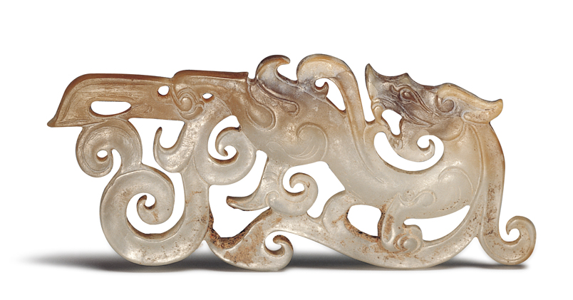 汉代．龙纹玉佩 此器以长方形玉料制作，龙身拉长为波浪状，其余玉料透雕为鬃鬣和长尾。（图二）  