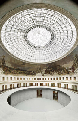 安藤忠雄在原本的圆形穹顶空间中，新增了清水混凝土的环形结构体，在老空间当中创造了全新的“舞台”，通过玻璃穹顶，自然光能洒进室内，照亮空间与19世纪的壁画。 