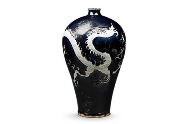 元代．蓝地刻花白云龙纹梅瓶+龙纹采浅刻法制作，表面施透明釉，其余器面用钴与釉调成的蓝釉，烧成蓝地白花之装饰。（图三）+图片来源：震旦博物馆藏